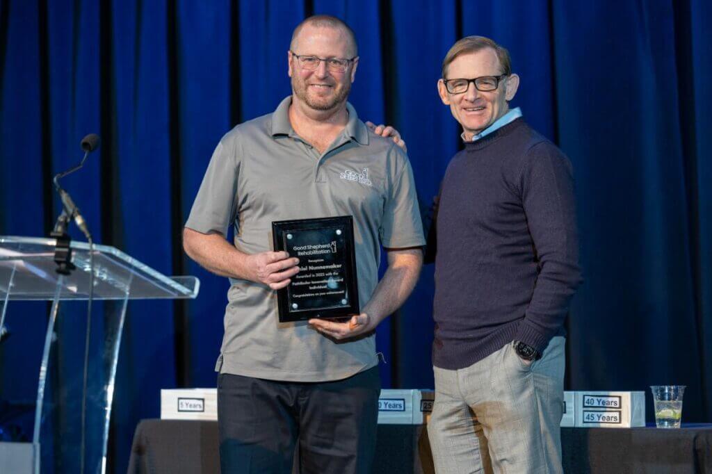 Daniel Nunnemaker holds the Good Shepherd Rehabilitation Pathfinder Innovation Award while posing for a photo with President & CEO Michael Spigel