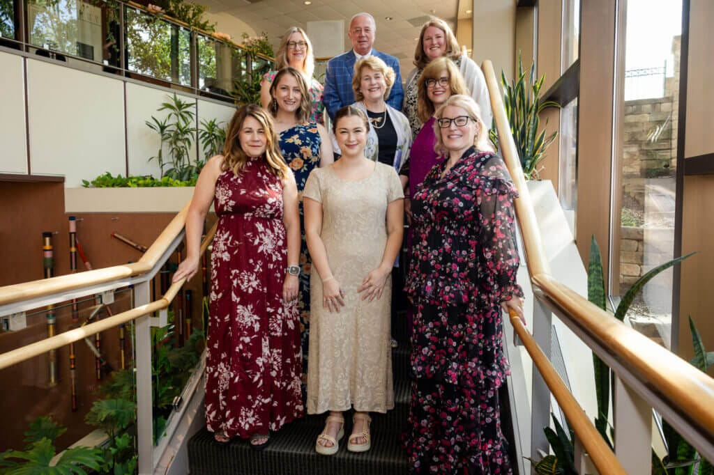 A group of nine people standing on the stairwell at Good Shepherd's Hyland Center