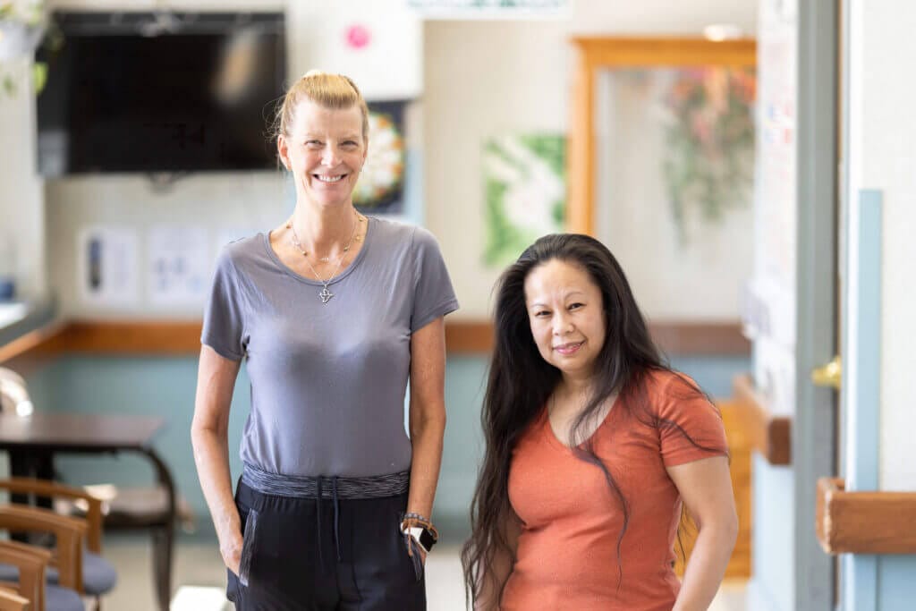 Two Good Shepherd employees smiling at the camera