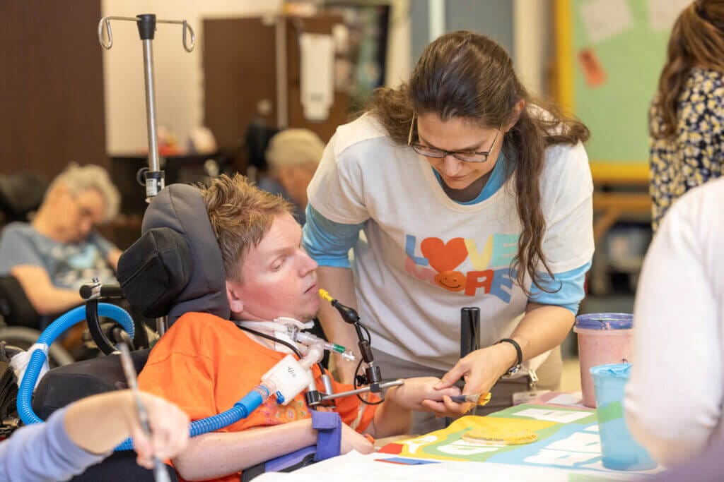 long-term care residents participating in a painting activity with Good Shepherd staff