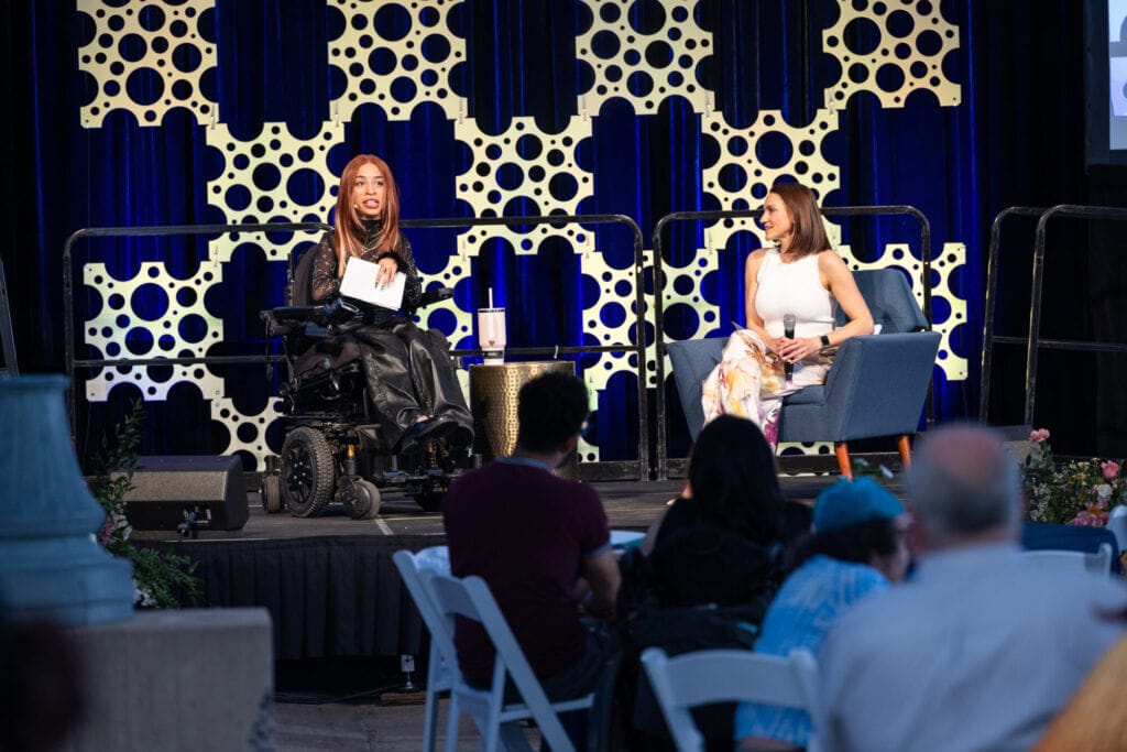 Jillian Mercado and Melanie Falcon sit on stage