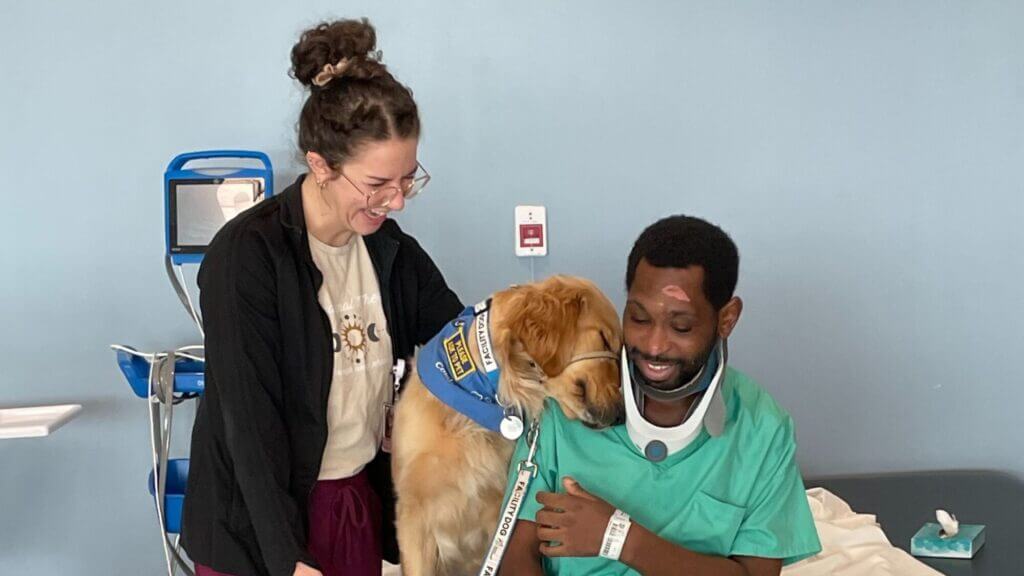 Nellie works with a patient at Good Shepherd Rehabilitation Hospital as a therapist stands nearby and smiles