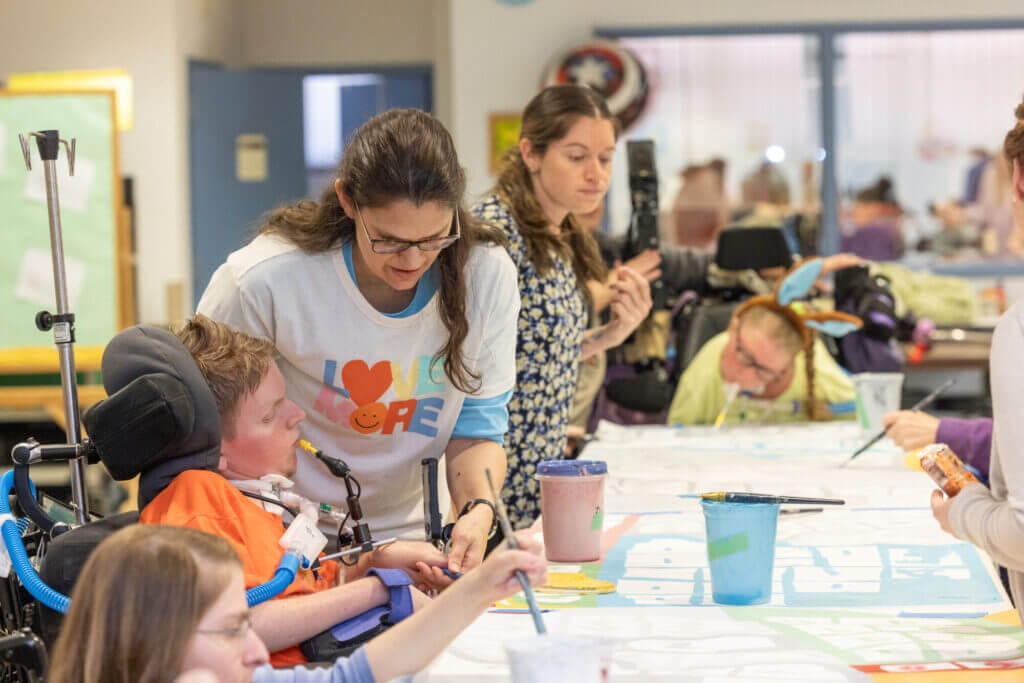 Good Shepherd Home - Raker Center residents paint panels on Good Shepherd's mural at a paint party, while Good Shepherd staff help.